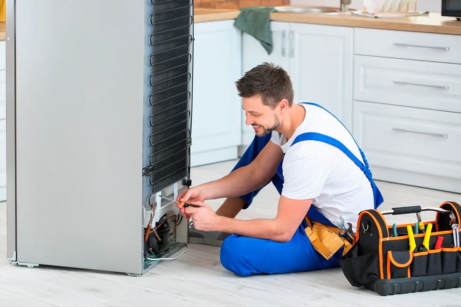 Técnico haciendo la reparación de una nevera a domicilio en Barcelona
